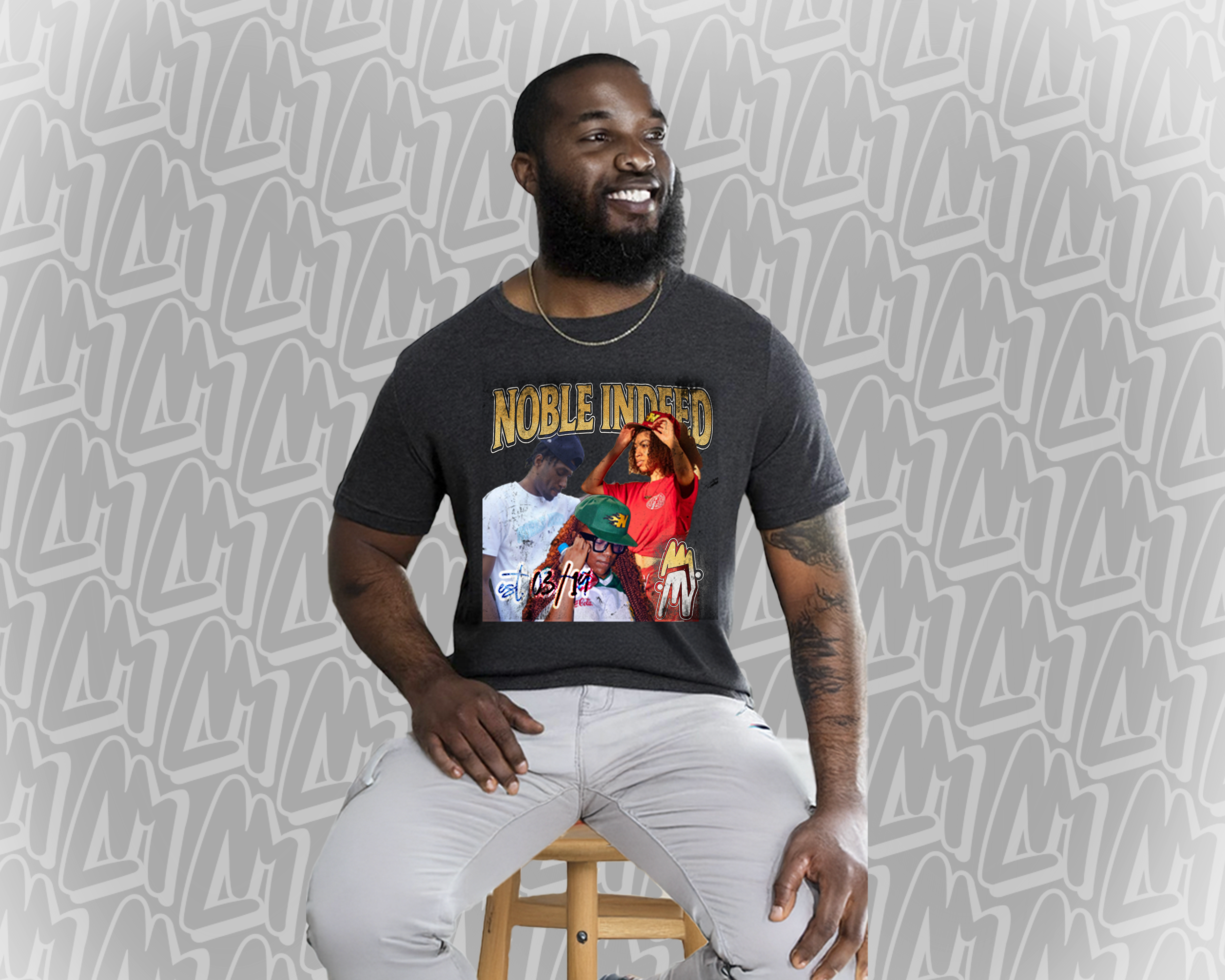 A bearded man wearing a black NobleIndeed t-shirt. The t-shirt has several rappers on it, and is in a 90's bootleg t-shirt style.